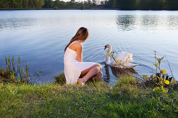 istock blond woman on water background and swan 96980897