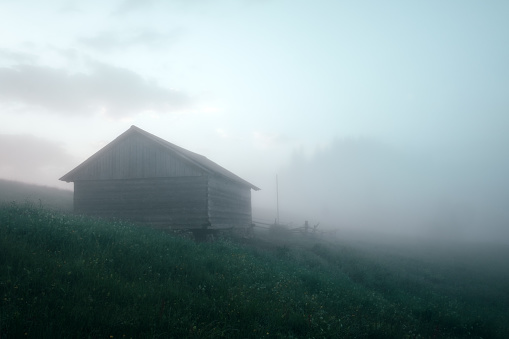 Mountain valley during sunrise. Alone house on foggy meadow. Located place: Carpathians, Ukraine, Europe
