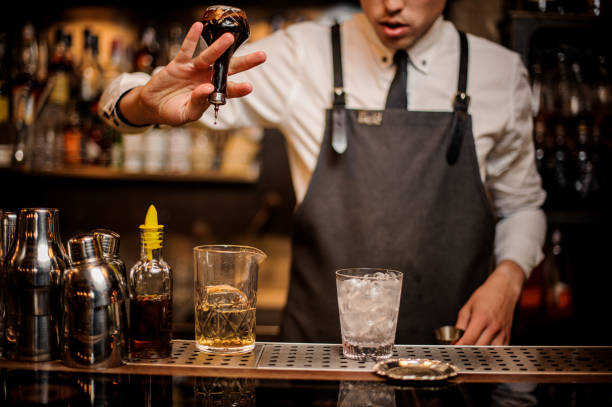 istock Brunet bartender adding an alcoholic essence into the mixing glass 969827206