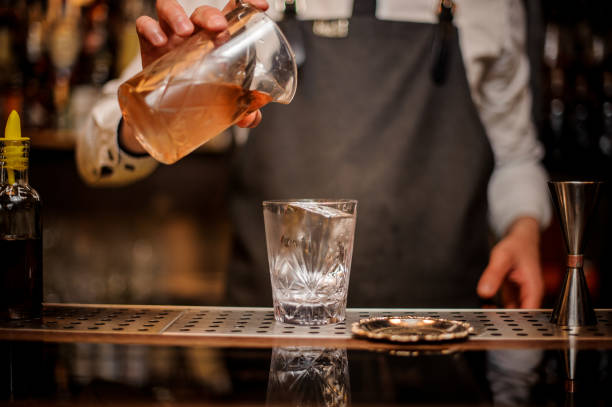 istock Bartender pouring an alcoholic drink from a mixing glass 969831648