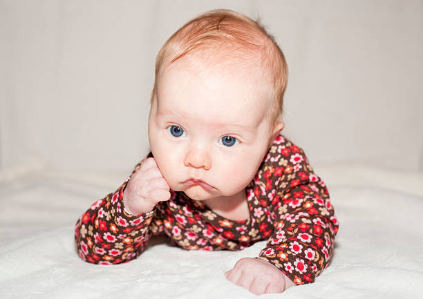 Two month old baby lying on a towel. Happy expression
