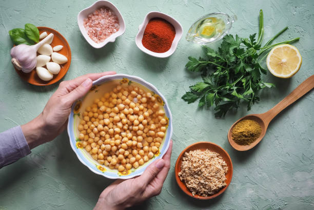 istock Chickpeas in hand. Ingredients for traditional hummus on the kitchen table. 969841622