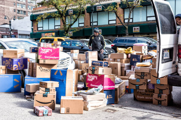 Delivery man with many boxes in NYC by BH photo video store, van truck unloading amazon prime, walmart, chewy, blue apron New York City, USA - October 30, 2017: Delivery man with many boxes in NYC by BH photo video store, van truck unloading amazon prime, walmart, chewy, blue apron amazon.com photos stock pictures, royalty-free photos & images
