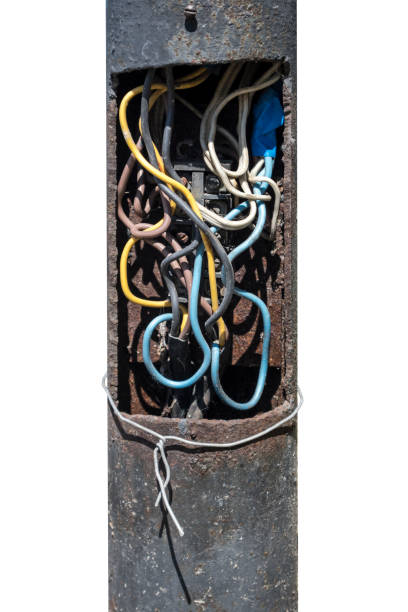 Metal black mast of an electric street light with colorful wires. Metal black mast of an electric street light with colorful wires. rusty pole stock pictures, royalty-free photos & images