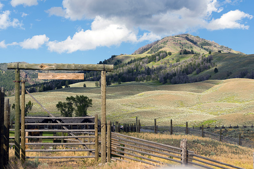 A livestock fence and entrance gate to a working western ranch