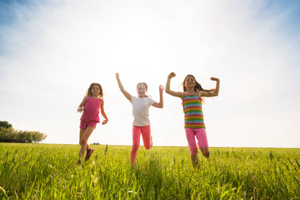 istock Beauty girls running through grass field 969853248