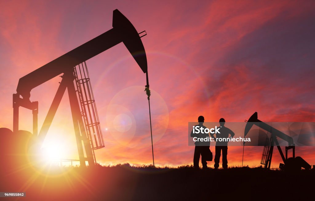 Puesta de sol sobre Pumpjack silueta con copia espacio - Foto de stock de Petróleo libre de derechos