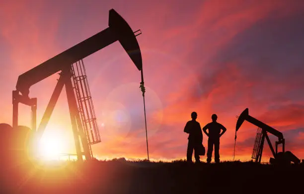 Photo of Sunset Over Pumpjack Silhouette With Copy Space