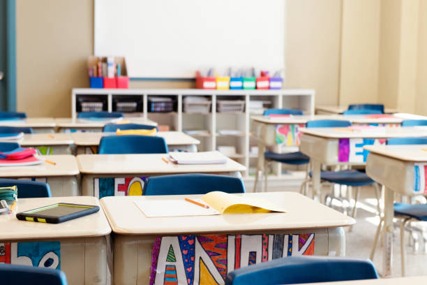 Classroom without children at the end of school named often school's out. Classroom without children at school's out. The desks are in rows and you can read the names of the children on the front of the desks drawn in multicolour. Photo was taken in elementary school in Quebec Canada. disappear stock pictures, royalty-free photos & images