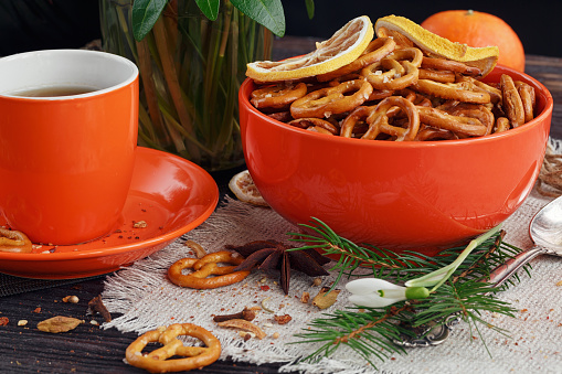 Cup of coffee is decorated by cookies, snowdrops and spices on a wooden table