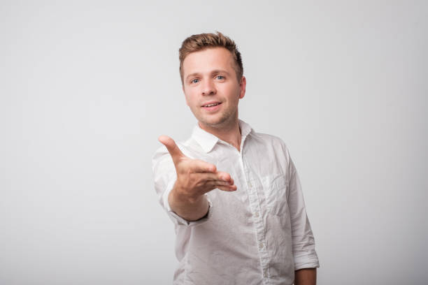 istock Caucasian man in white shirt shaking hands isolated on white background. 969865588