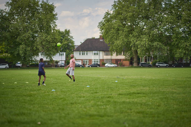 due giovani che giocano a calcio in un parco nel sud-est di londra. - southeast england foto e immagini stock