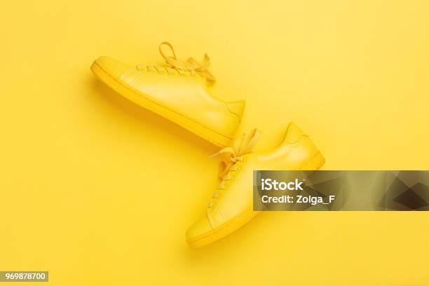 One Pair Of Yellow Shoes On Yellow Background Stock Photo - Download Image Now - Yellow, Shoe, Sports Shoe