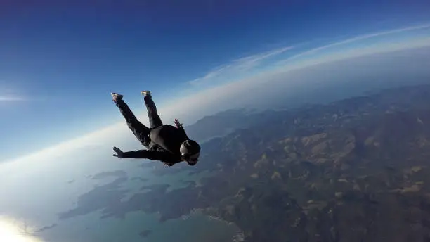 Photo of Skydiver jump over the sea and mountains