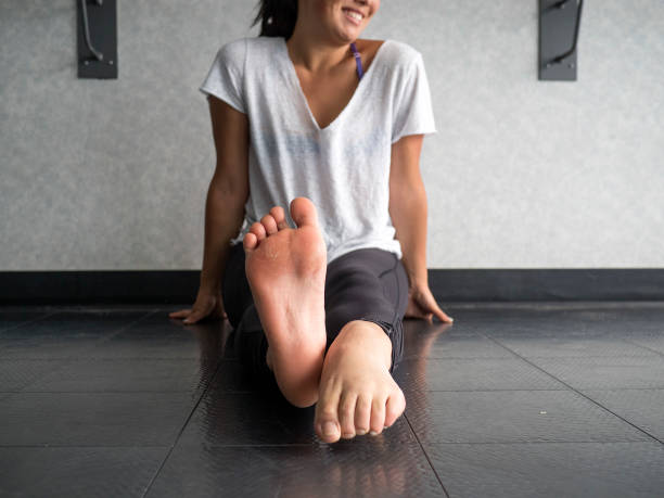 istock Smiling dancer warming up her feet with alternating pointing and flexing 969887696