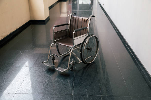 sedia a rotelle nel corridoio dell'ospedale. sedia a rotelle vuota parcheggiata in patient rooms in ospedale. - disablement foto e immagini stock