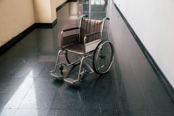 病院の廊下で車椅子。空の車椅子は、病院の病室に駐車。 - disablement ストックフォトと画像