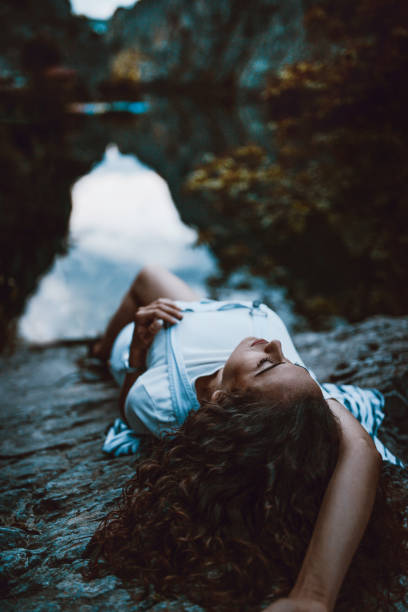 istock Sensual Female Lying On Cliff Near Mountain Lake 969909504