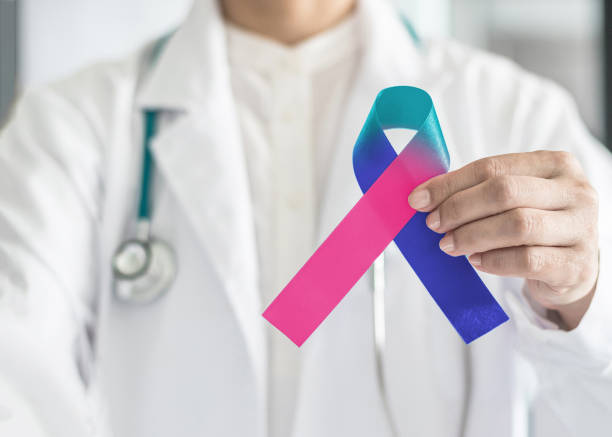 Thyroid cancer awareness ribbon in Teal Pink Blue symbolic bow color in doctor's hand to support patient with tumor illness Thyroid cancer awareness ribbon in Teal Pink Blue symbolic bow color in doctor's hand to support patient with tumor illness follicular thyroid cancer stock pictures, royalty-free photos & images