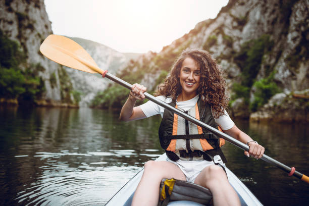 istock Female Athlete Rowing Through Lake On Kayaking Trip 969912474