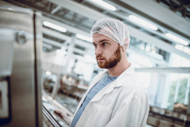 istock Male Factory Engineer With Hair Net Analyzing Production Line 969917406