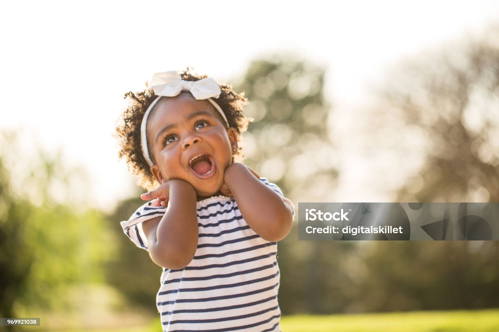 Happy little girl laughing and smiling outside. Happy African American little girl laughing and smiling outside. Toddler Stock Photo