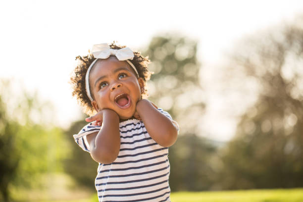 Happy little girl laughing and smiling outside. stock photo