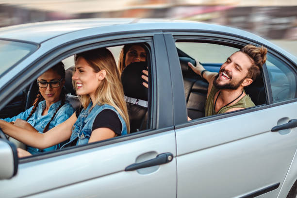 istock Friends riding in the car with open windows and laughing 969927574