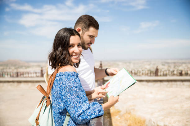istock Pretty young woman holding map with boyfriend 969940510
