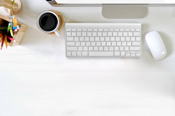 istock Stylish office table desk. Workspace with computer, colour pencils and coffee mug on white wooden background. Flat lay, top view 969949182