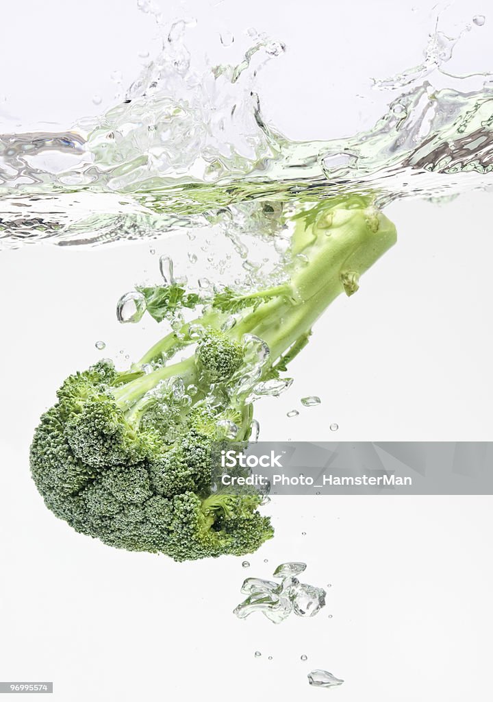 Green broccoli falling in water with air bubbles  No People Stock Photo
