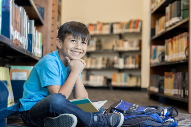 istock Happy little boy in school library 969970526
