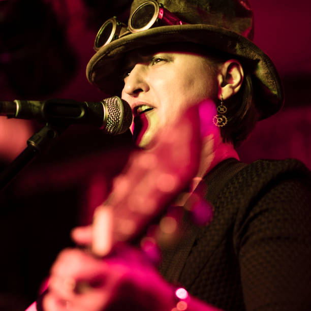 il video ritratto della matura, 45 anni, donna, musicista e cantante, che indossa il costume steampunk con il cappello e i google - 40 45 years immagine foto e immagini stock