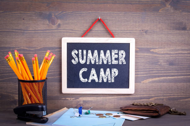 istock Summer camp. Chalkboard on a wooden background 969985030