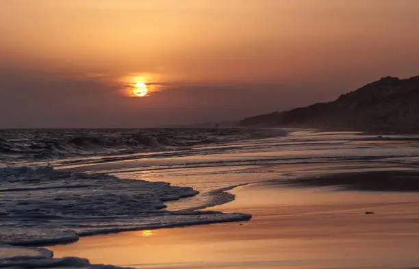 Sunset Reflexion on the beach , Mazagon , Huelva , Andalusia , Atlantic coast , Spain. Waves on the beach, tourist destination