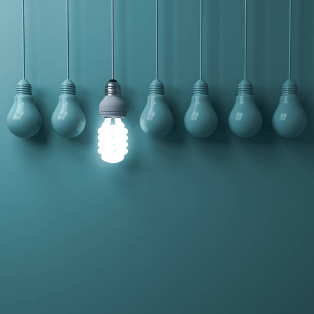 istock One hanging eco energy saving light bulb glowing and standing out from unlit incandescent bulbs on green pastel color wall background , leadership and different creative idea concepts 3D rendering 970003448