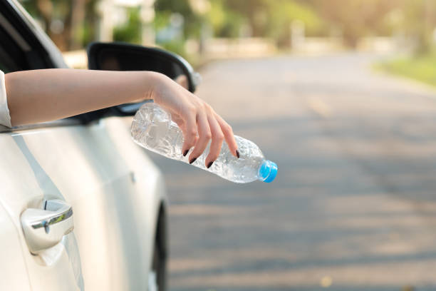 istock Hand throwing plastic bottle on the road 970007216