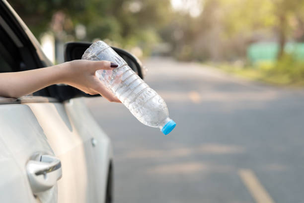istock Hand throwing plastic bottle on the road 970007226