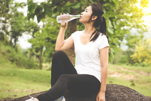 istock Asian woman drinking water from bottle after doing exercise 970021020