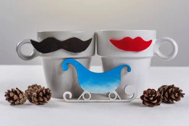 Winter holidays for couples. Symbolic cups are man-woman, and winter accessories.