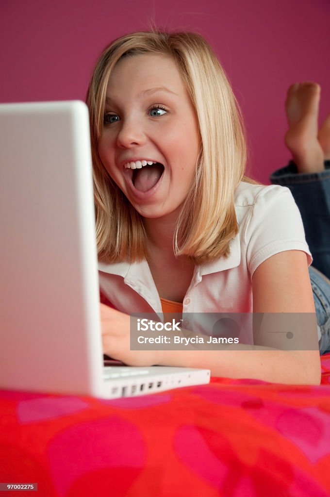 Ridere felice Teen Ragazza su computer - Foto stock royalty-free di Abbigliamento casual