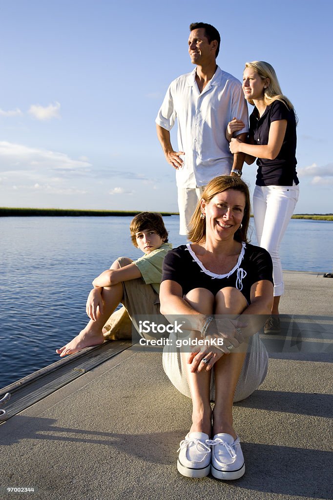 Madre e famiglia, giornata di sole sul dock dall'acqua - Foto stock royalty-free di 14-15 anni