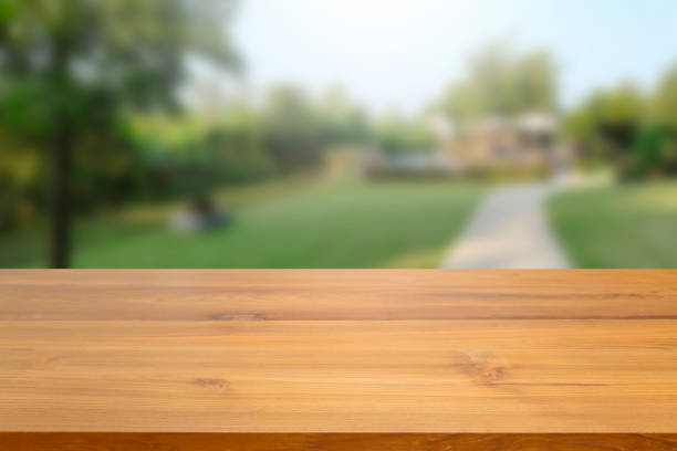 istock Empty wood table top against blurred green nature and tree background. used for display or montage your products advertisement. 970031660