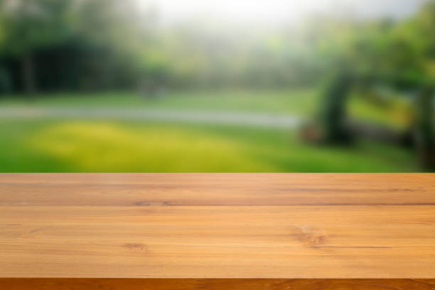 istock Empty wood table top against blurred green nature and tree background. used for display or montage your products advertisement. 970031730