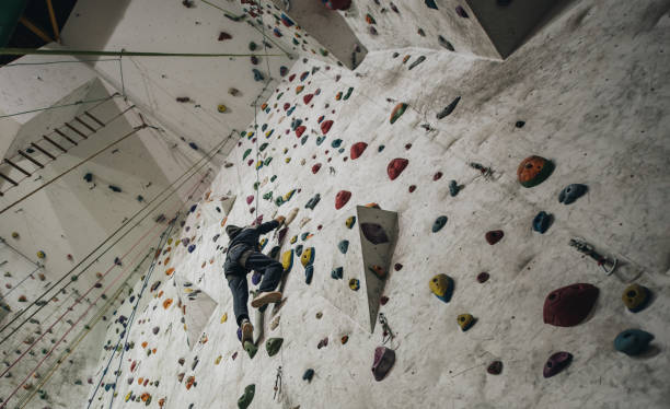 istock Low angle view of athletic man climbing on the wall in a gym. 970036892