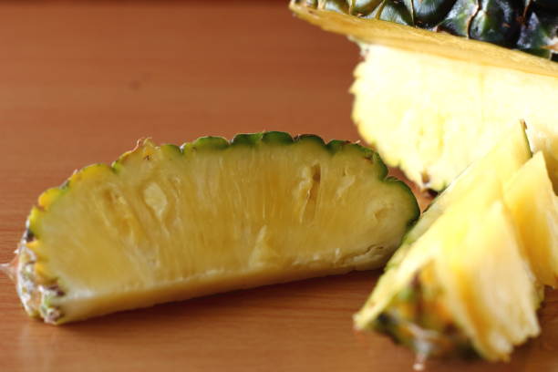 istock Ripe pineapple and pineapple slices on wooden 970042888
