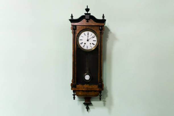 old wooden pendulum hanging on a wall on blue background. - clock face clock deadline human hand imagens e fotografias de stock