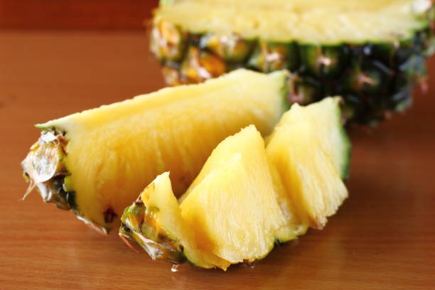 istock Ripe pineapple and pineapple slices on wooden 970046630