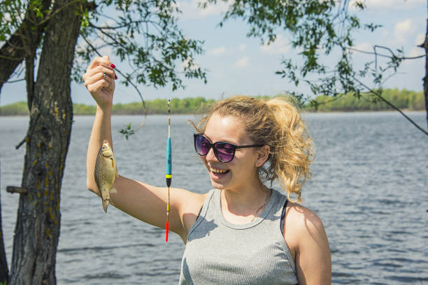 istock girl holding a fish caught in her hand 970053818