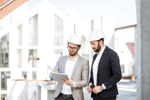 inżynierowie z tabletem na konstrukcji - foreman building contractor hardhat men zdjęcia i obrazy z banku zdjęć